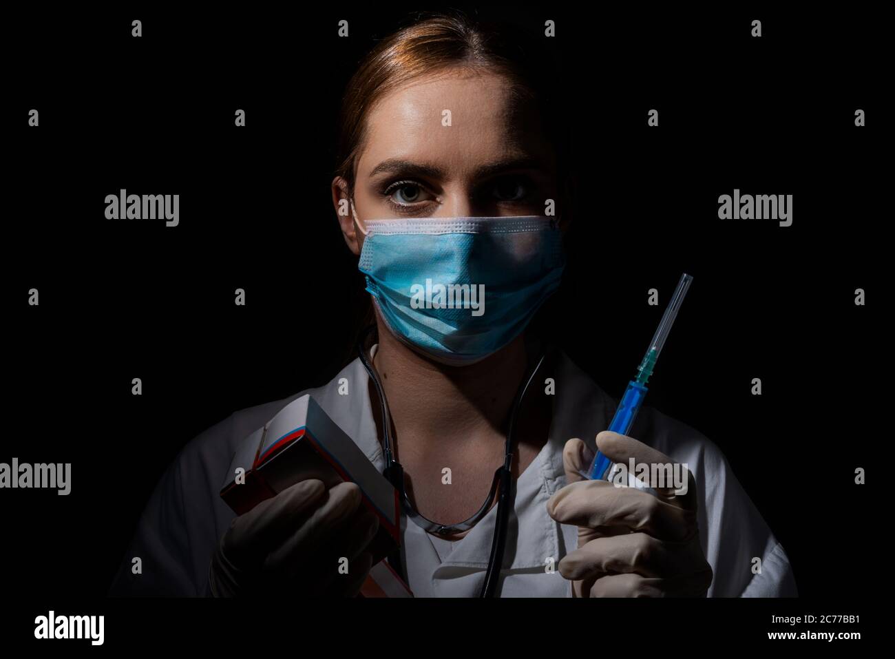 Medico femminile con maschera contenente il vaccino e pillole in mano, vaccino coronavirus, covid-19 cura Foto Stock