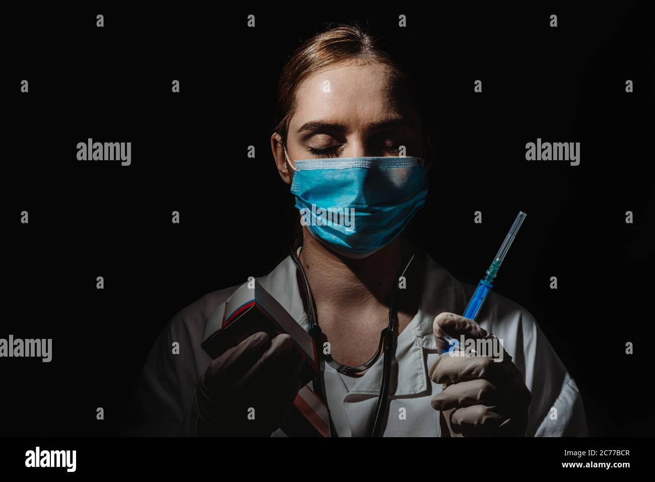 Medico femminile con maschera contenente il vaccino e pillole in mano, vaccino coronavirus, covid-19 cura Foto Stock