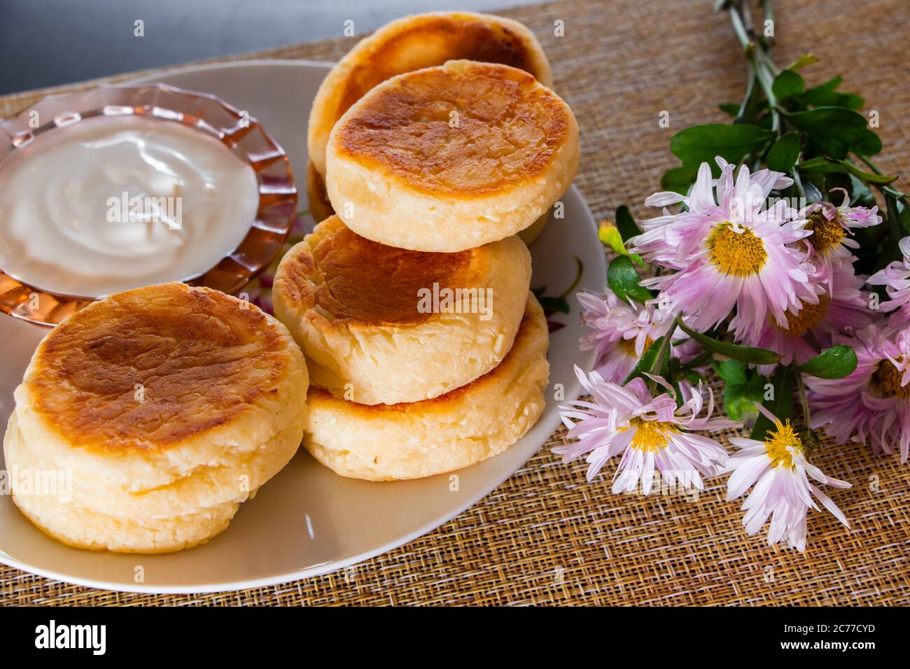 Colazione fatta in casa - deliziosi frittelle di formaggio cottage su un piatto con marmellata e panna acida. Foto Stock