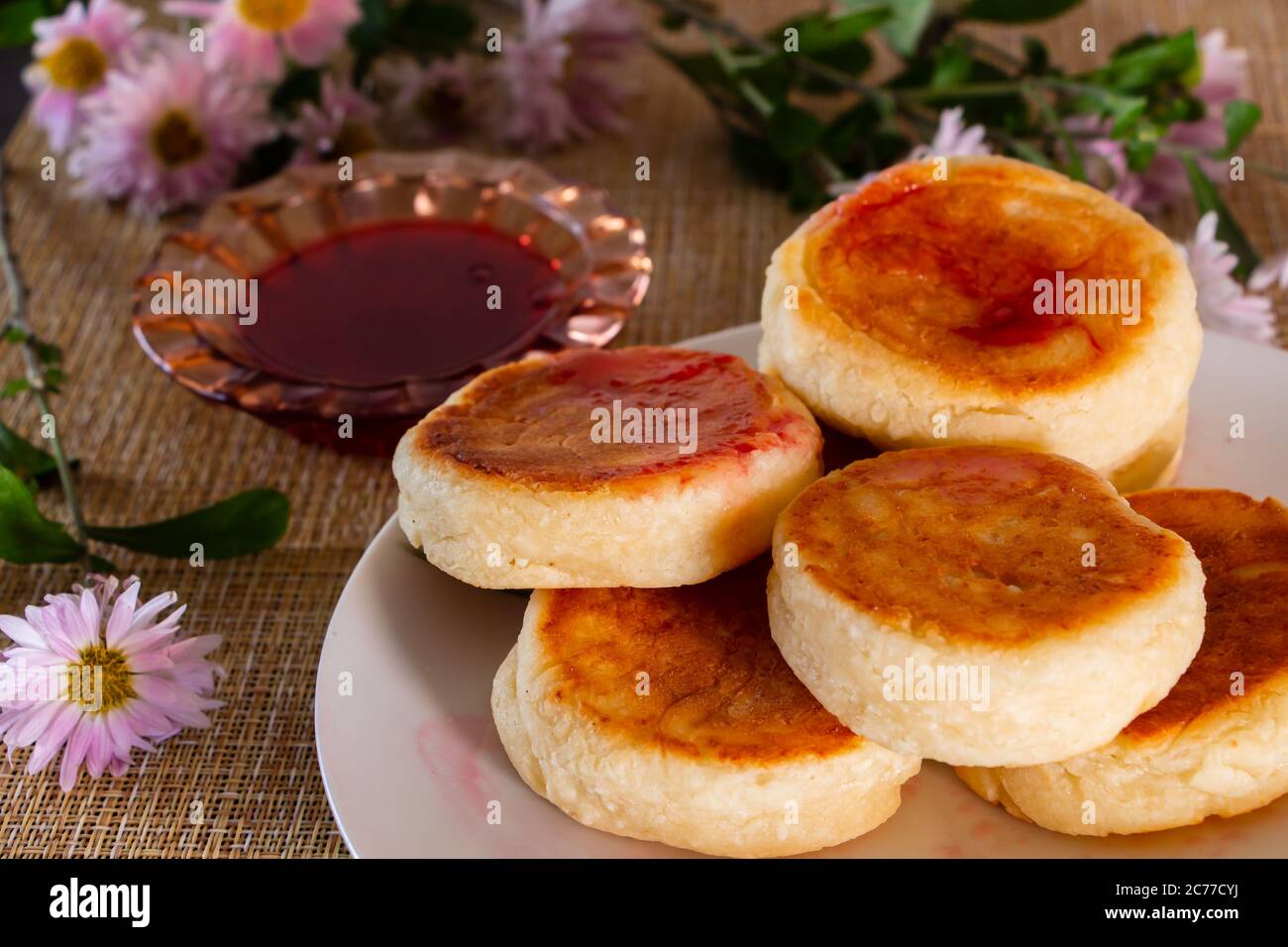 Colazione fatta in casa - deliziosi frittelle di formaggio cottage su un piatto con marmellata e panna acida. Foto Stock