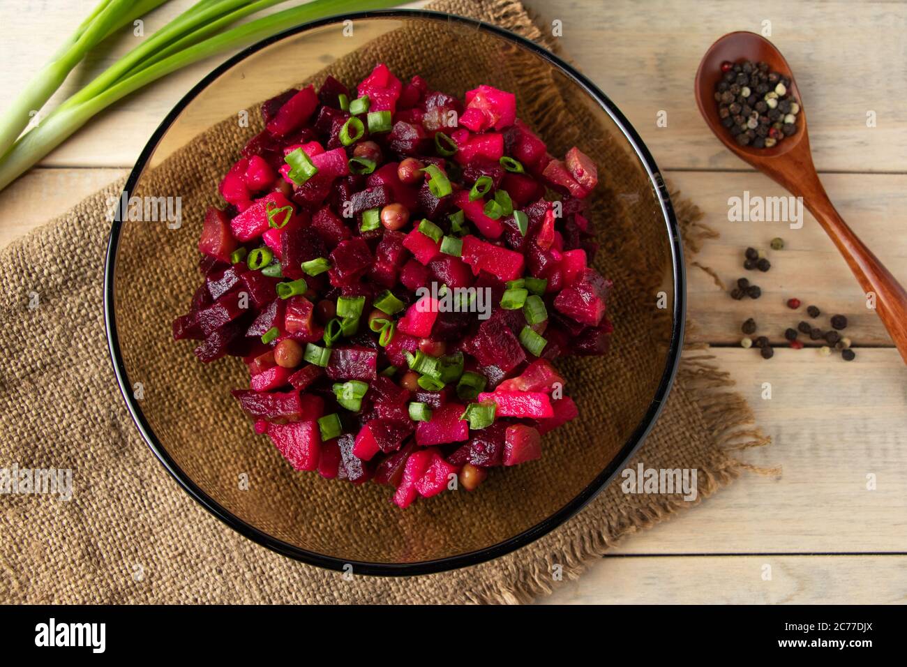 Vinaigrette su sfondo ligneo. Insalata russa di verdure con barbabietole rosse in un recipiente. Stile rustico, piatto tradizionale. Foto Stock