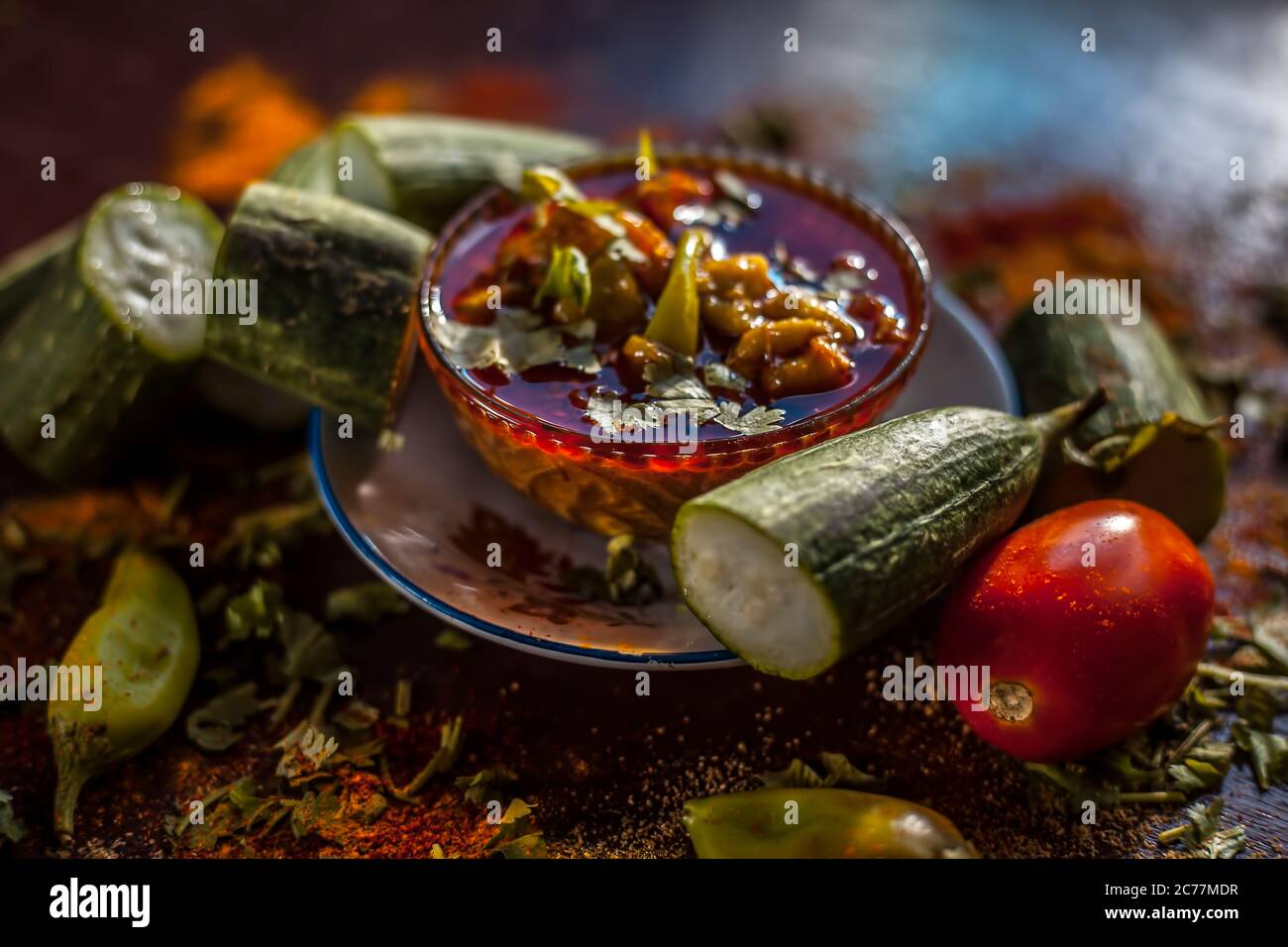 Primo piano della famosa Galka Nu Shaak di Gujarati su un piatto di vetro. Shot di spugna gourd piatto in un piatto di vetro insieme con tutte le spezie su un marrone con Foto Stock