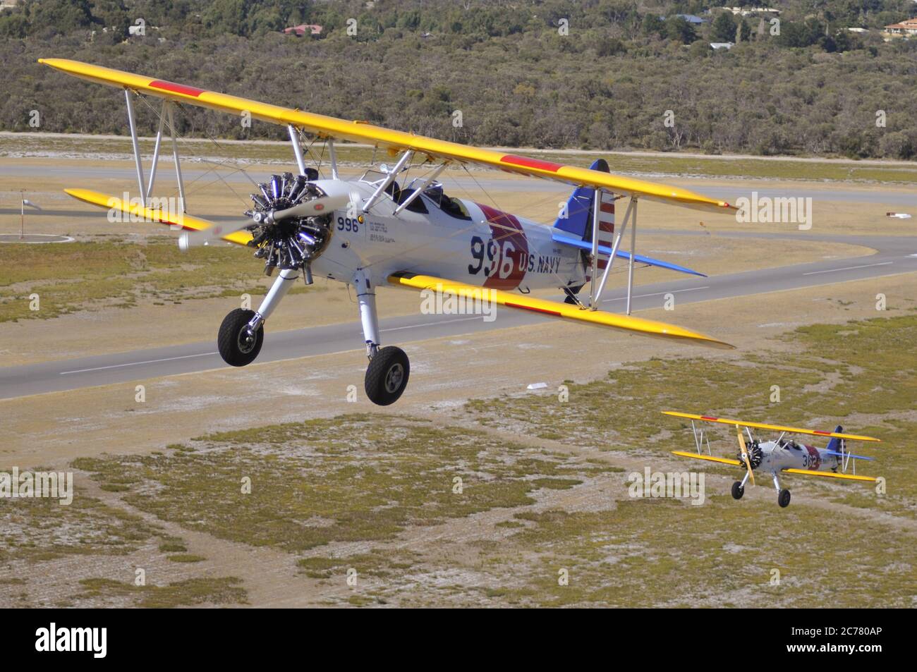 Un ritratto aria-aria, di due addestratori biplanari Stearman della Marina degli Stati Uniti restaurati degli anni '40 che decolgono da un campo aereo. Foto Stock