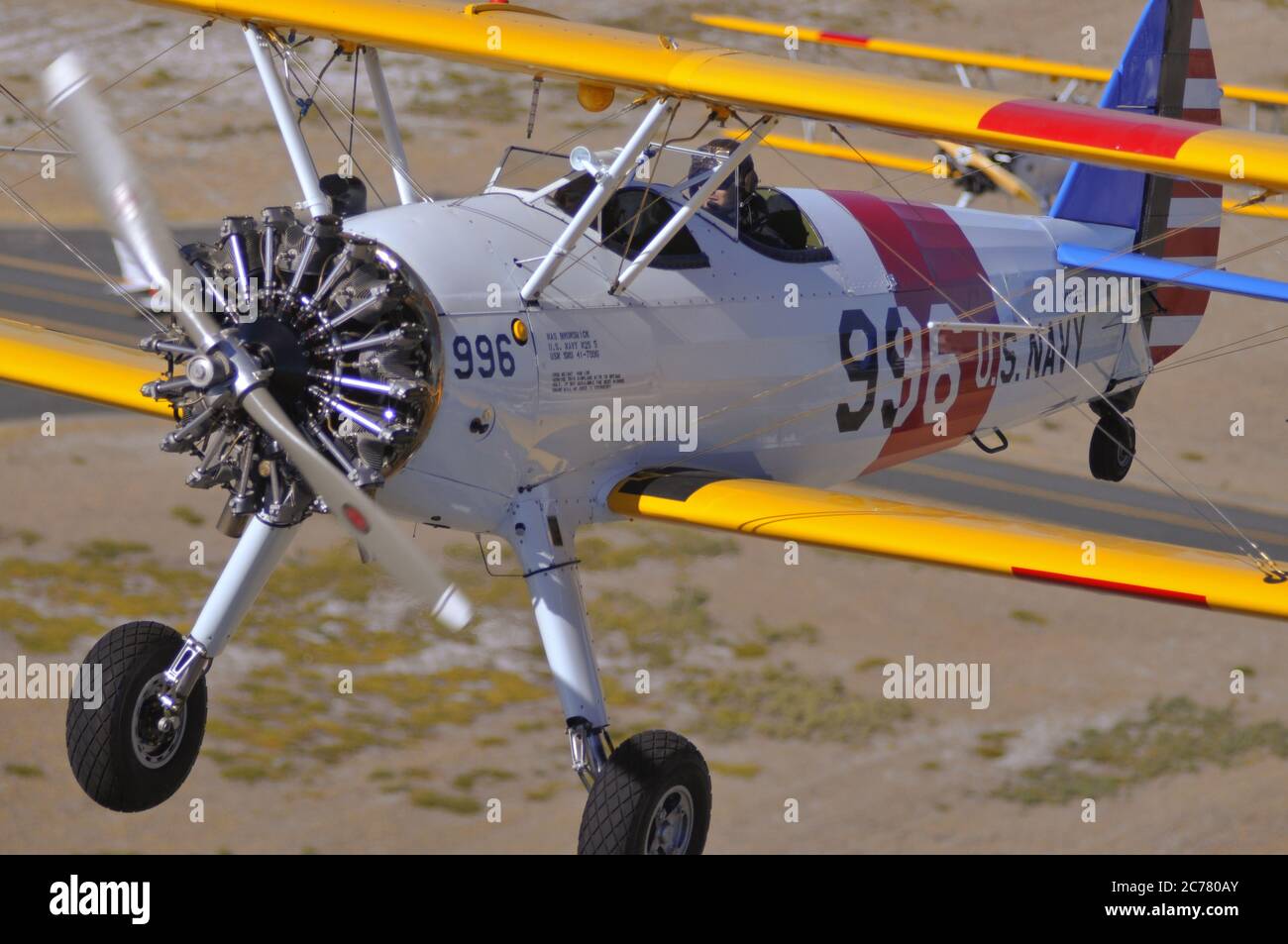 Un ritratto aria-aria, di due addestratori biplanari Stearman della Marina degli Stati Uniti restaurati degli anni '40 che decolgono da un campo aereo. Foto Stock
