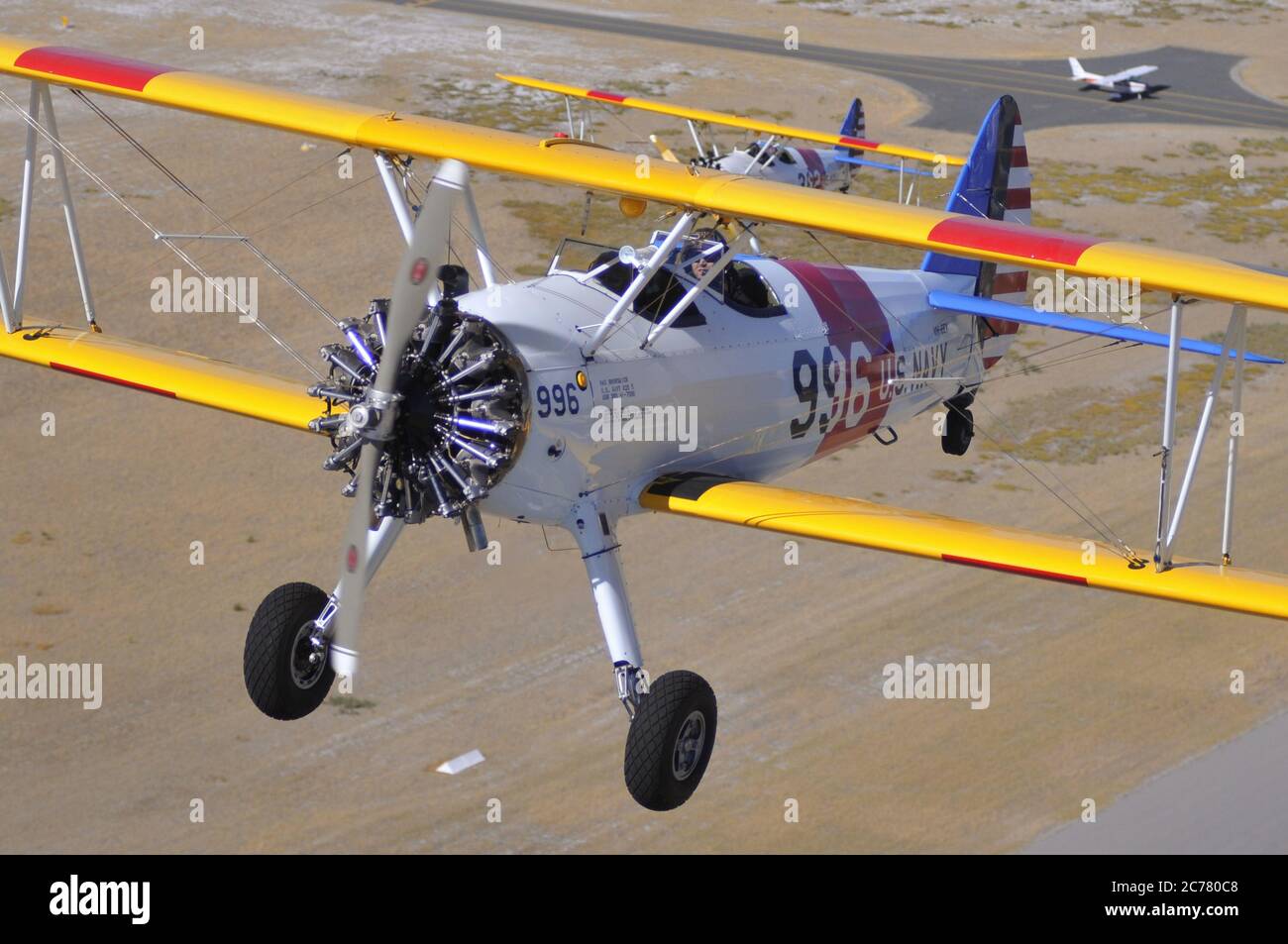 Un ritratto aria-aria, di due addestratori biplanari Stearman della Marina degli Stati Uniti restaurati degli anni '40 che decolgono da un campo aereo. Foto Stock