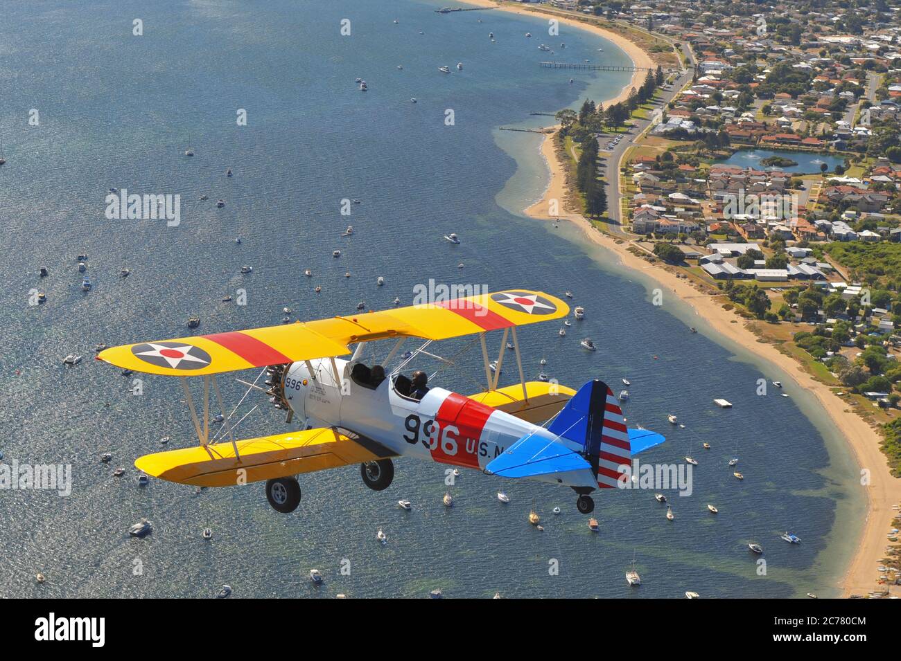 Un ritratto BirdsEye Air to Air, di un allenatore biplanare Stearman Boeing della Marina degli Stati Uniti restaurato degli anni '40 sull'oceano. Foto Stock