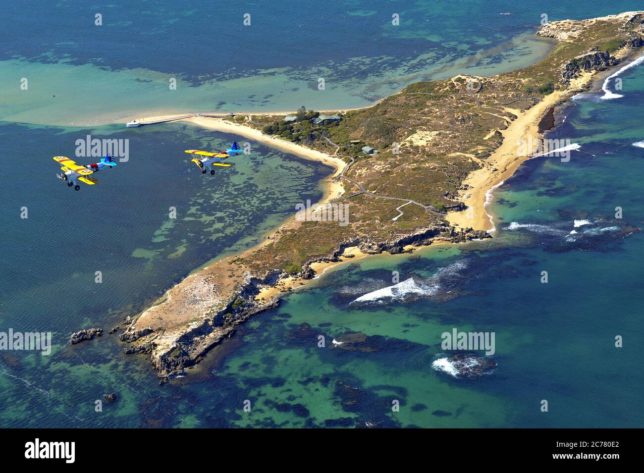 Un ritratto aria-aria, di un restaurato 1940's US Navy Boeing Stearman biplano addestratori su una piccola isola. Foto Stock