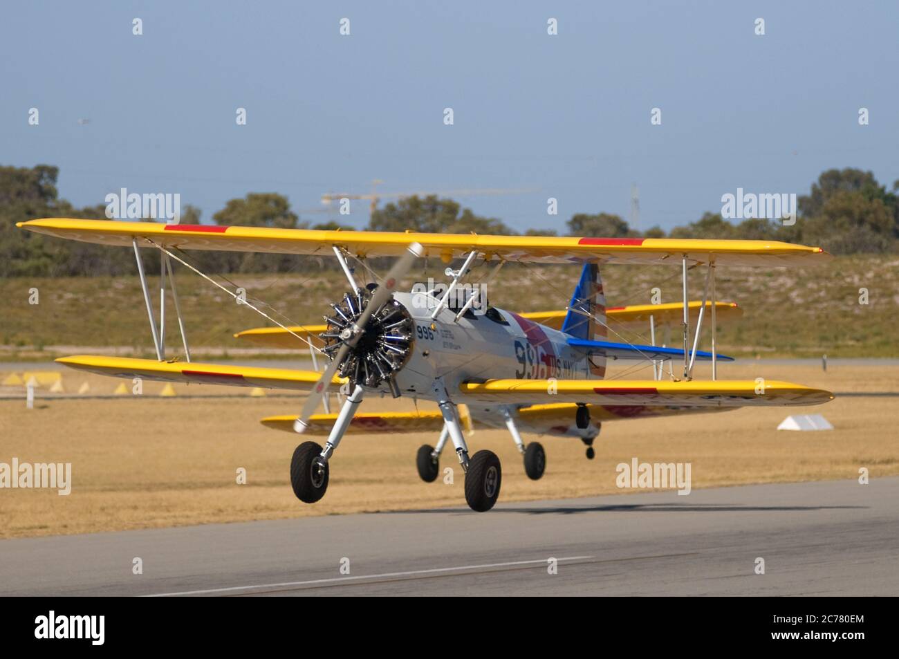 Un ritratto aria-aria, di due addestratori biplanari Stearman della Marina degli Stati Uniti restaurati degli anni '40 che decolgono da un campo aereo. Foto Stock