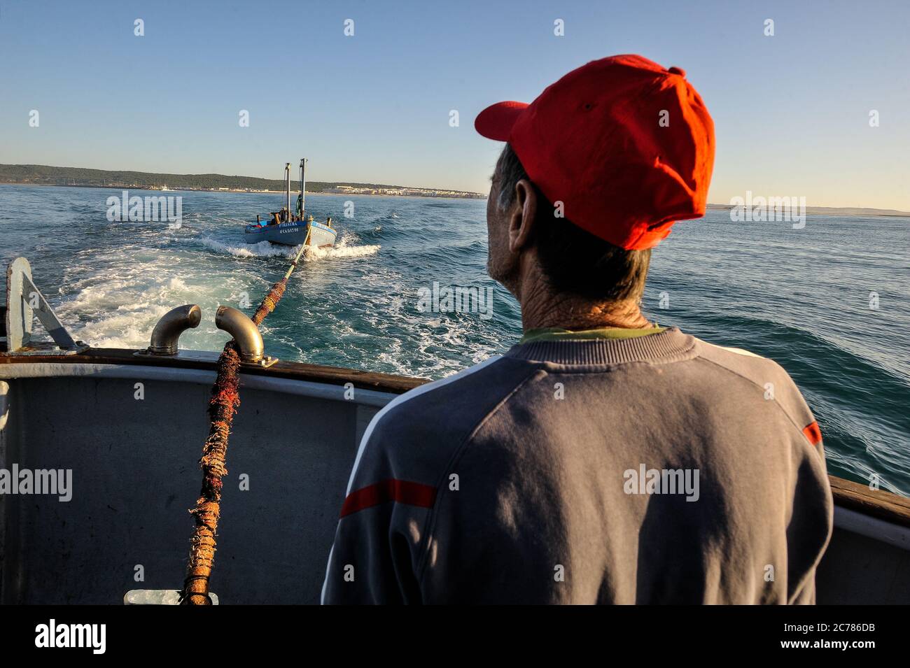 Un pescatore guarda la chiatta che viene trainata dalla nave da pesca sulla strada per la vista di Almadraba a Barbate, Spagna. Data: 06/06/2012. Fotografo: Xabier Mikel Laburu. Foto Stock