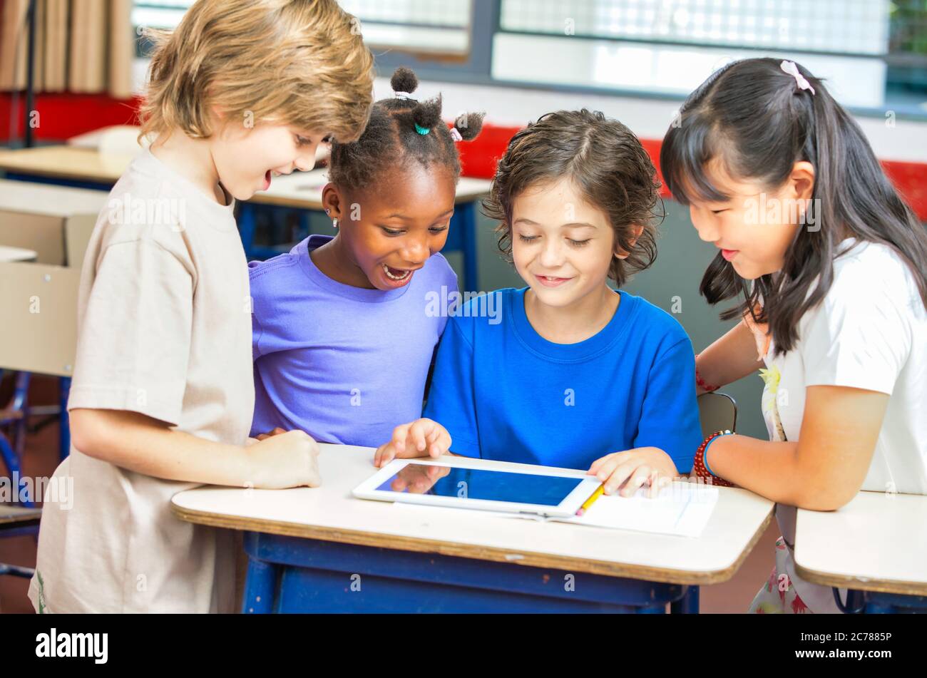 Scena scolastica elementare. I compagni di classe multietnici in classe imparano insieme. Concetto di ritorno a scuola Foto Stock