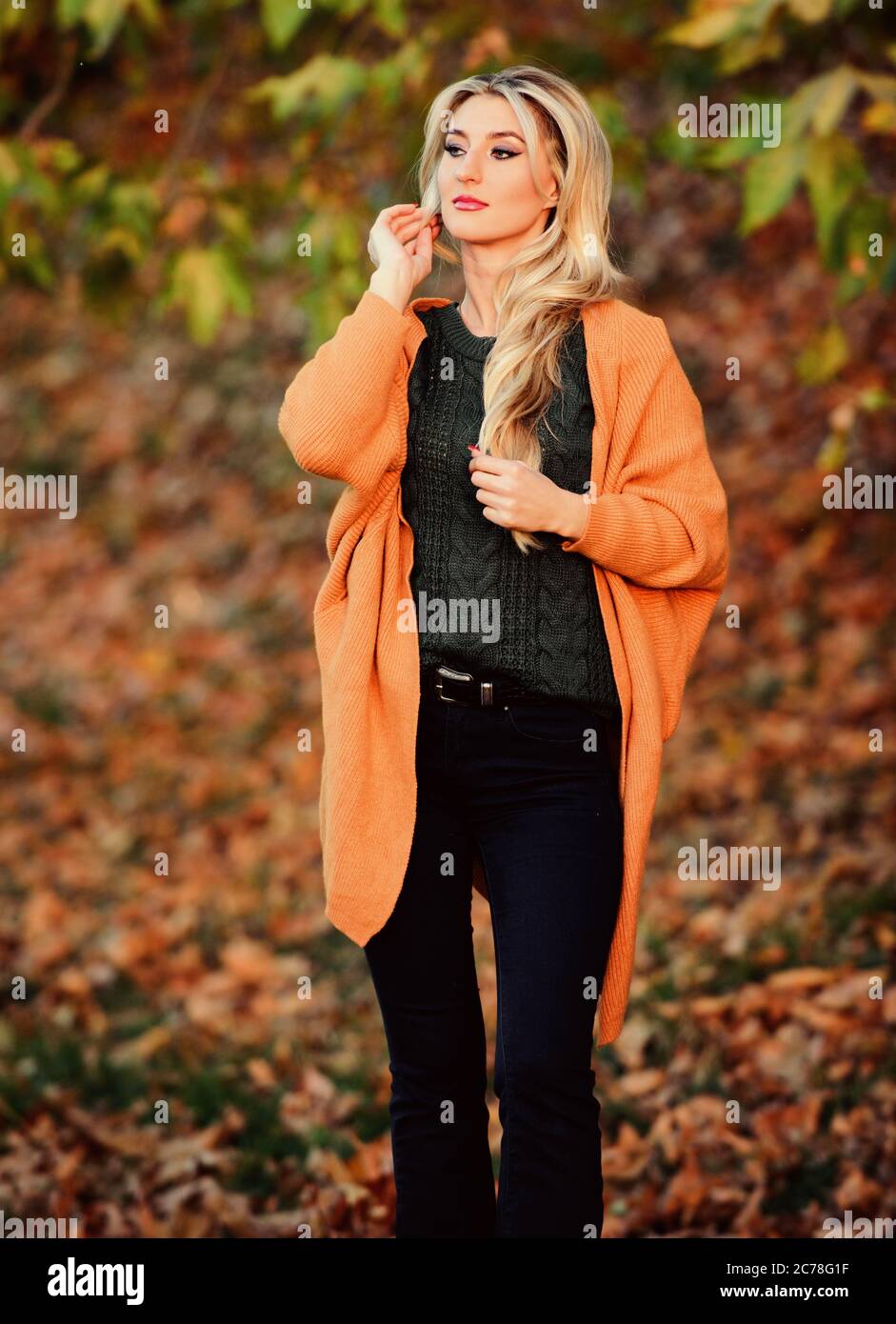 Ragazza adorabile bionda posa in caldo e accogliente vestito autunno natura  sfondo disfocused. Idee per un intimo outfit per il weekend. Donna  camminare luce del tramonto. Abbigliamento per tutti i giorni. Abiti