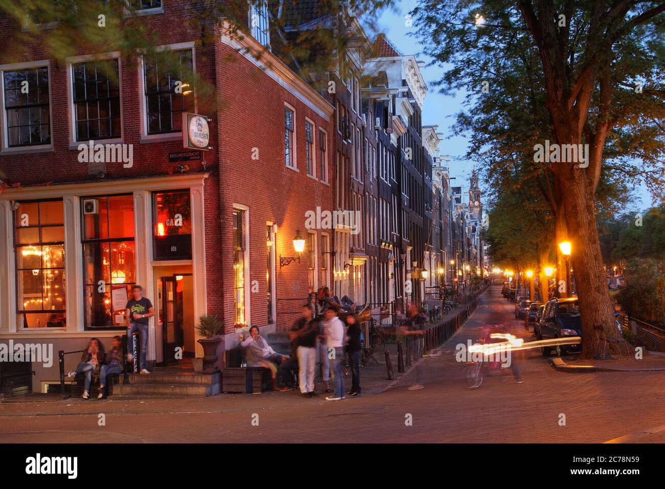 Scena notturna lungo i canali di Amsterdam, Paesi Bassi, durante l'estate. L'immagine raffigura la vita notturna informale tipica di Amsterdam. Foto Stock