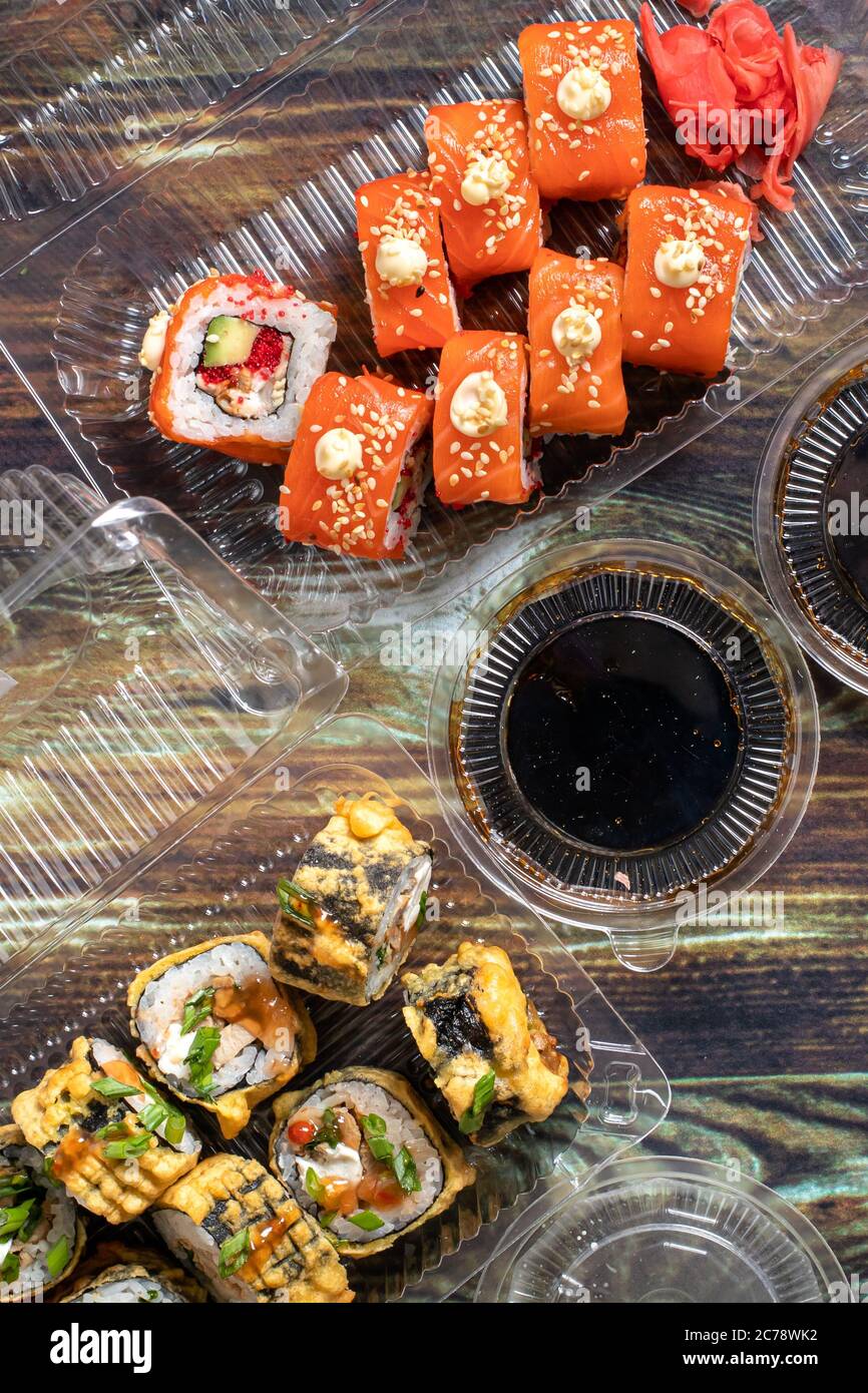 Consegna cibo home: Sushi, rotoli in contenitori monouso in plastica. Cucina tradizionale giapponese, pesce. Foto Stock