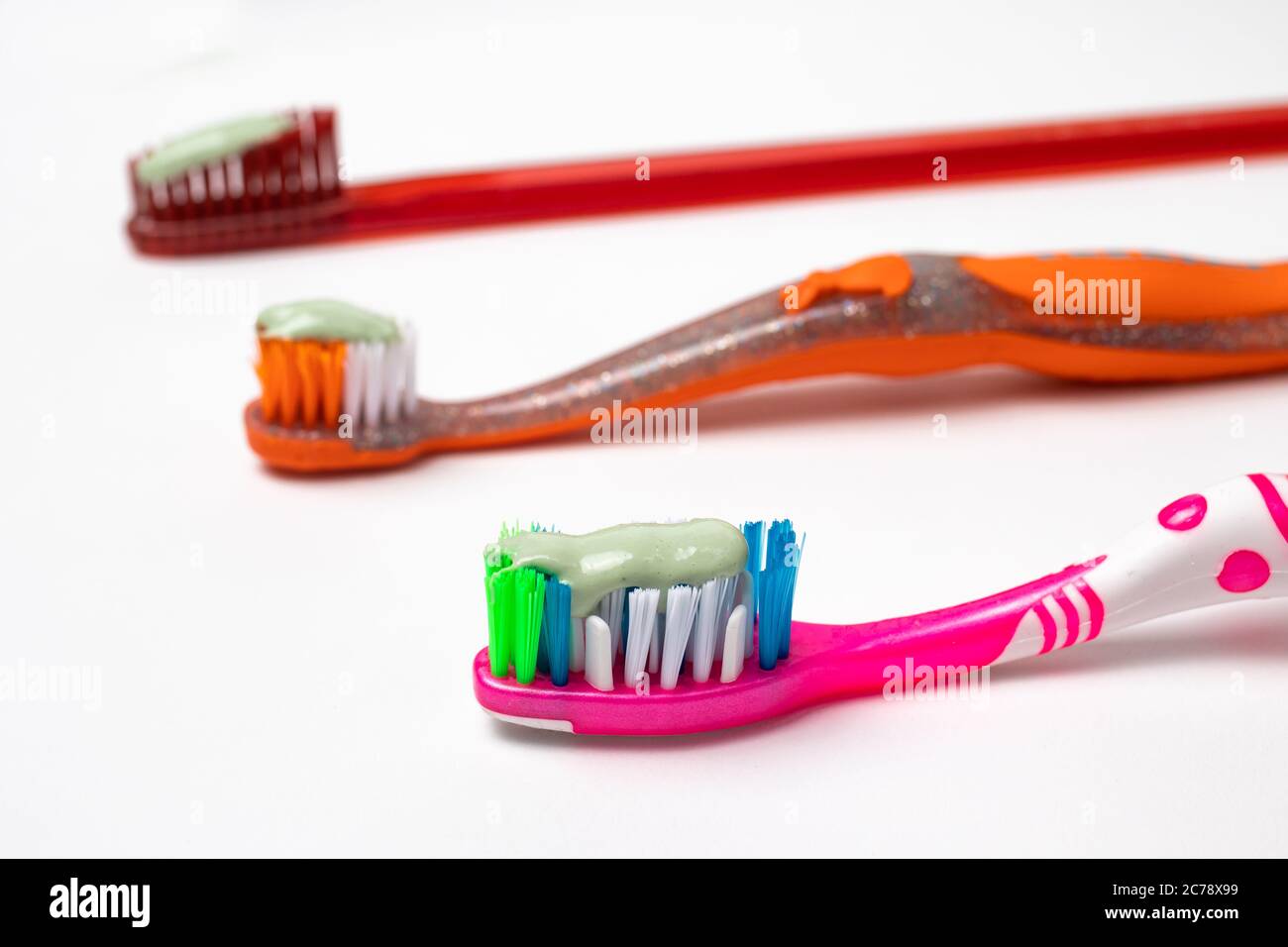 Tre spazzolini da denti per tutta la famiglia. Attenzione alla bocca, spazzolando i denti. Dentifricio e spazzolino da denti. Foto Stock