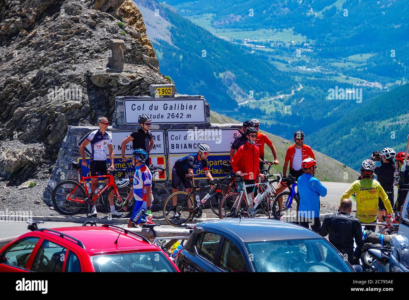 Folle di ciclisti che ottengono una fotografia, e le automobili al col du Galibier, un alto passo nel Parco Nazionale degli Ecrins, vicino a Briancon, Francia Foto Stock