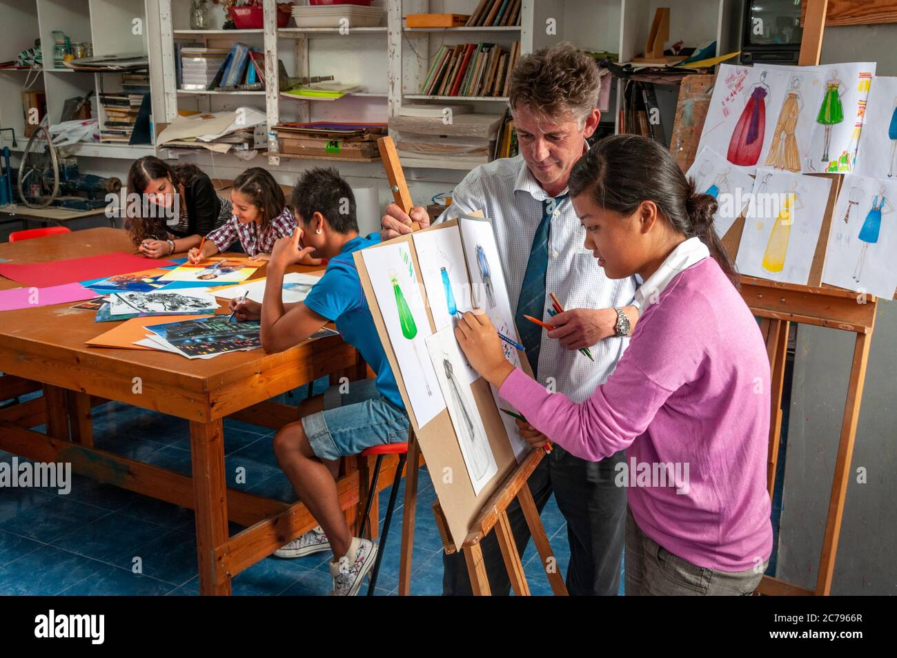 Scuola Art Class moda design con insegnante e adolescente studente che  lavora sulla sua moda design abbigliamento disegni progetto in scuola  d'arte classe Foto stock - Alamy