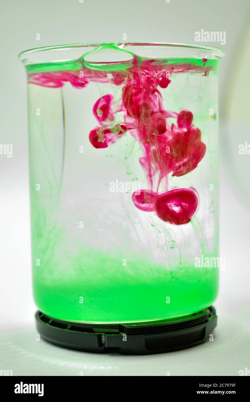 Una fotografia closeup di colore rosa e verde mescolato in acqua. Foto Stock
