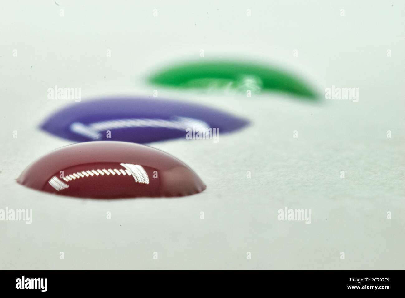 Una bella foto closeup di gocce di colore con riflesso di luci. Foto Stock