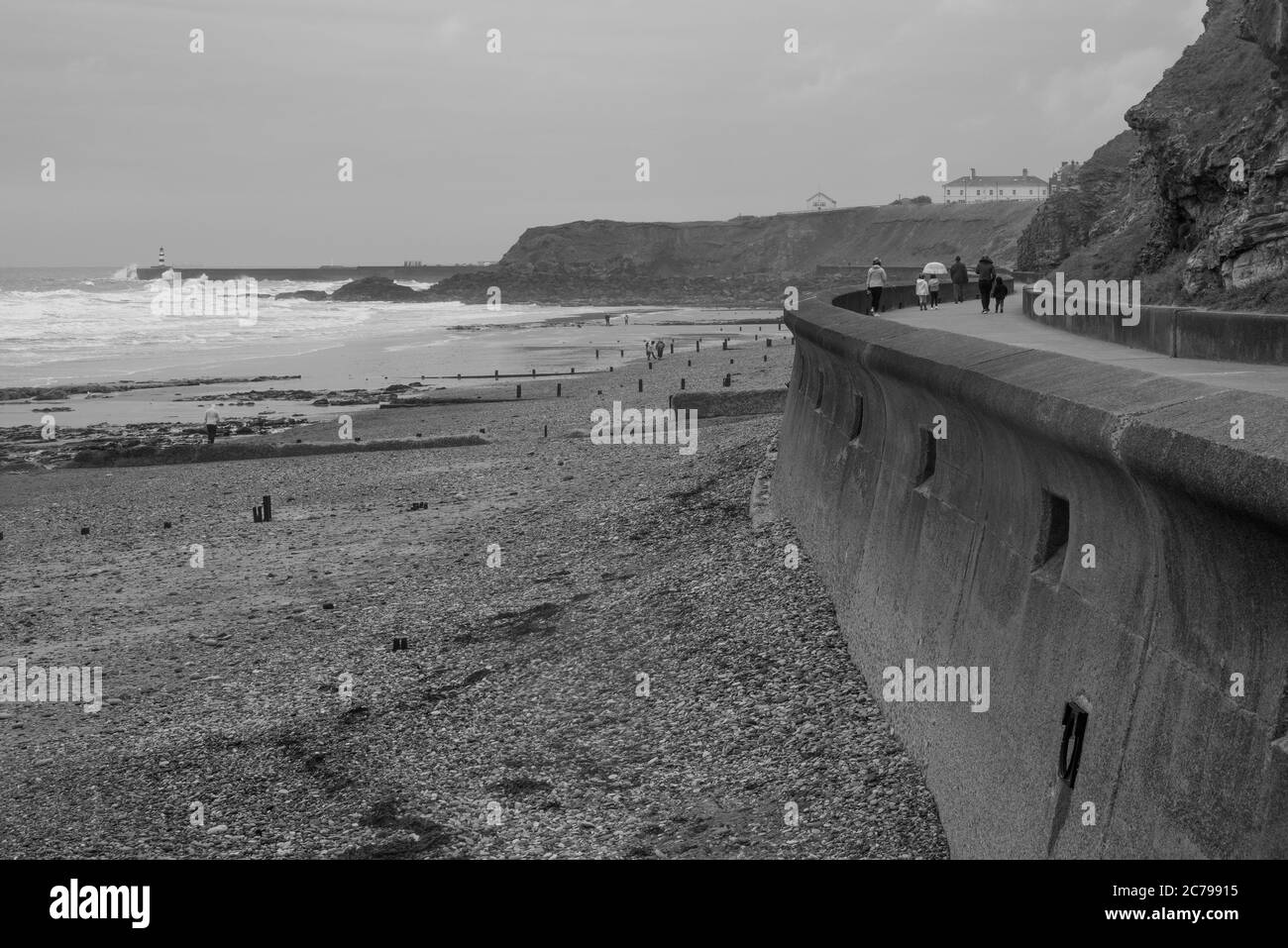 Immagine monocromatica della passeggiata lungo il bordo sia della spiaggia e scogliera in un giorno ventoso e piovoso in estate a Seaham nella contea di Durham Foto Stock