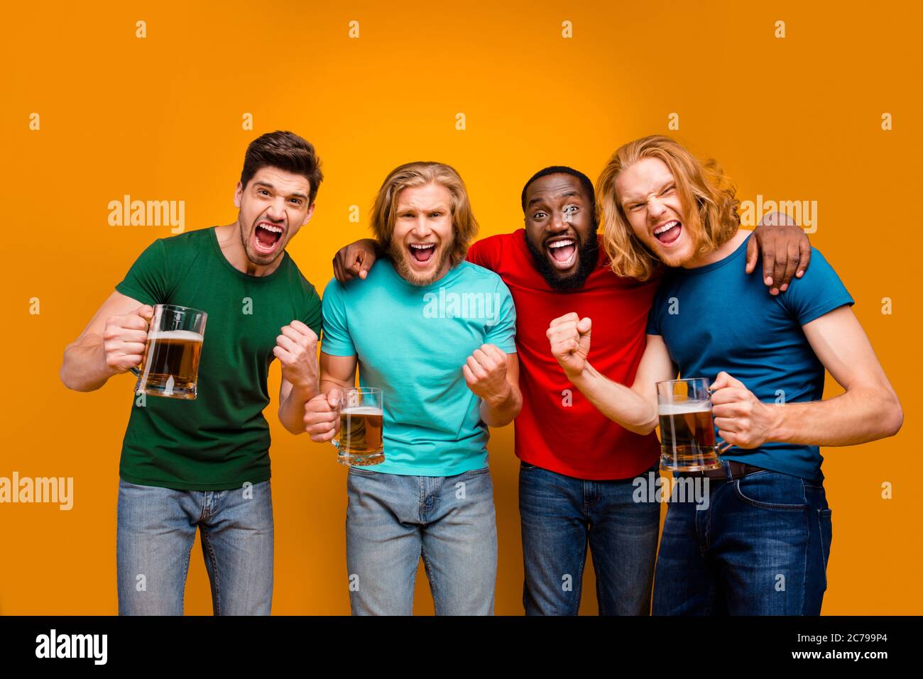 Ecstatic pazzo quattro amici uomini in bar guardare il mondo del calcio tazza di pinta di tenuta della tazza celebrano la vittoria della squadra nazionale solleva i pugni indossa jeans casual t-shirt Foto Stock