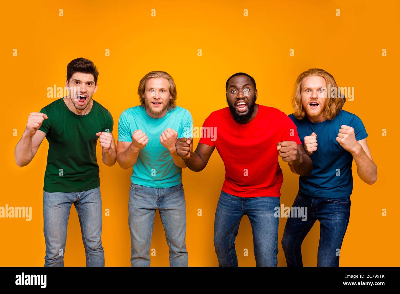 Foto di funky focalizzato quattro uomini studente guardare nazionale squadra supporto per partite di calcio della lega tenere pugni orecchio t-shirt jeans denim isolato su luminoso Foto Stock