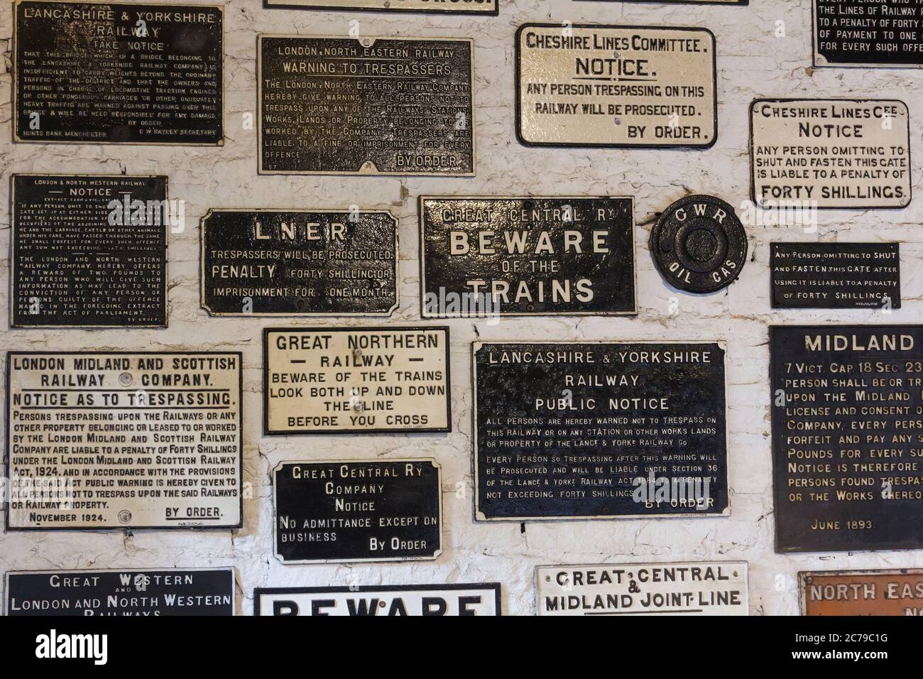 La compagnia ferroviaria in ghisa "no Trespassing" e altri segnali di avvertimento esposti su un muro presso il museo Ingrow Loco, noto anche come "The Engine Shed". Il museo è Foto Stock