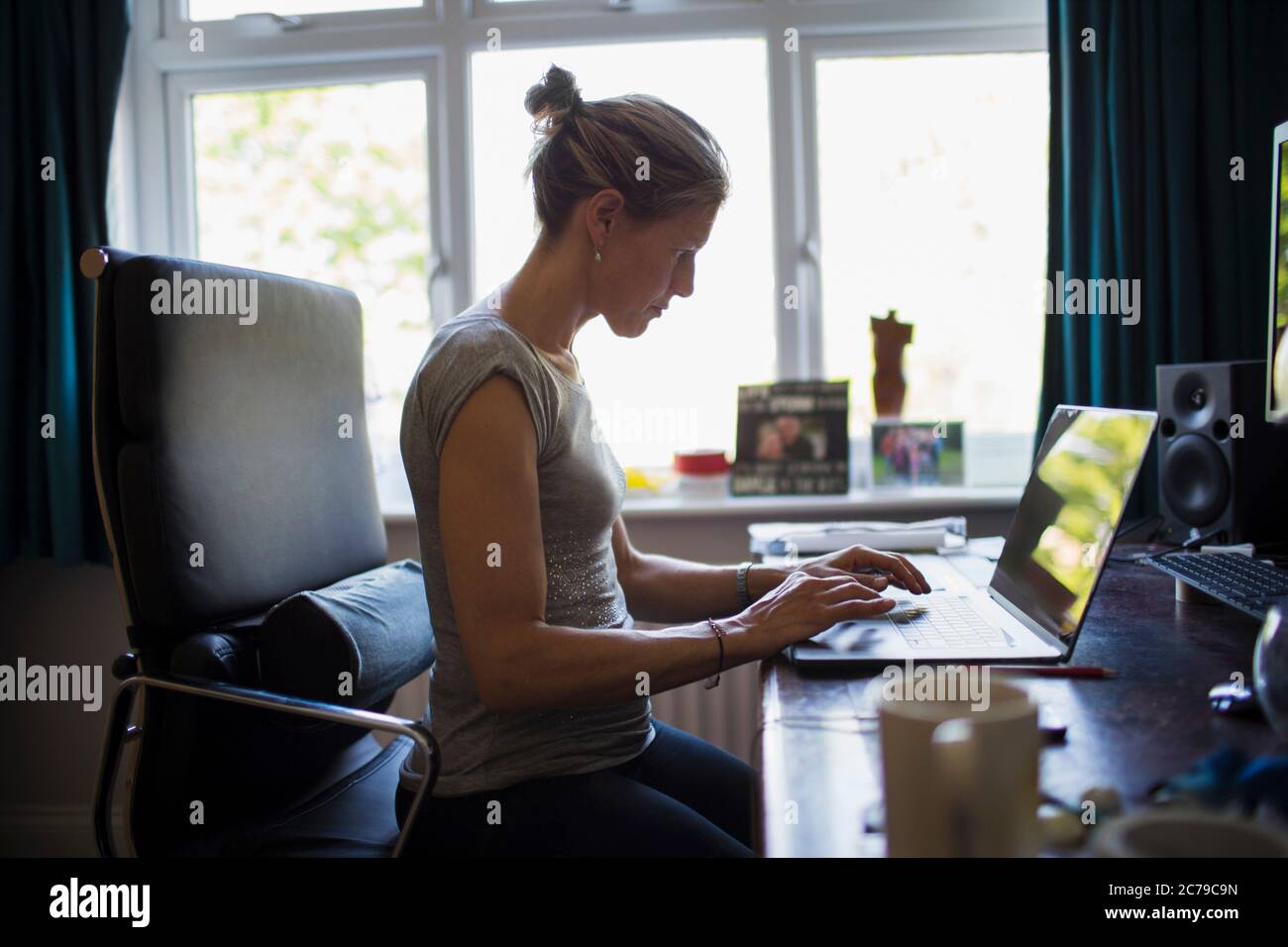 Donna che lavora da casa al computer portatile in ufficio Foto Stock