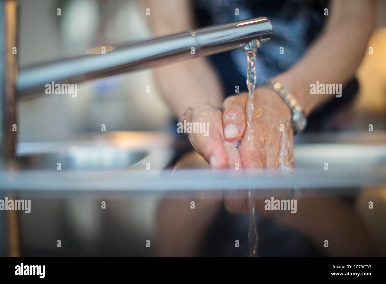 Primo piano donna lavando le mani al lavello della cucina Foto Stock