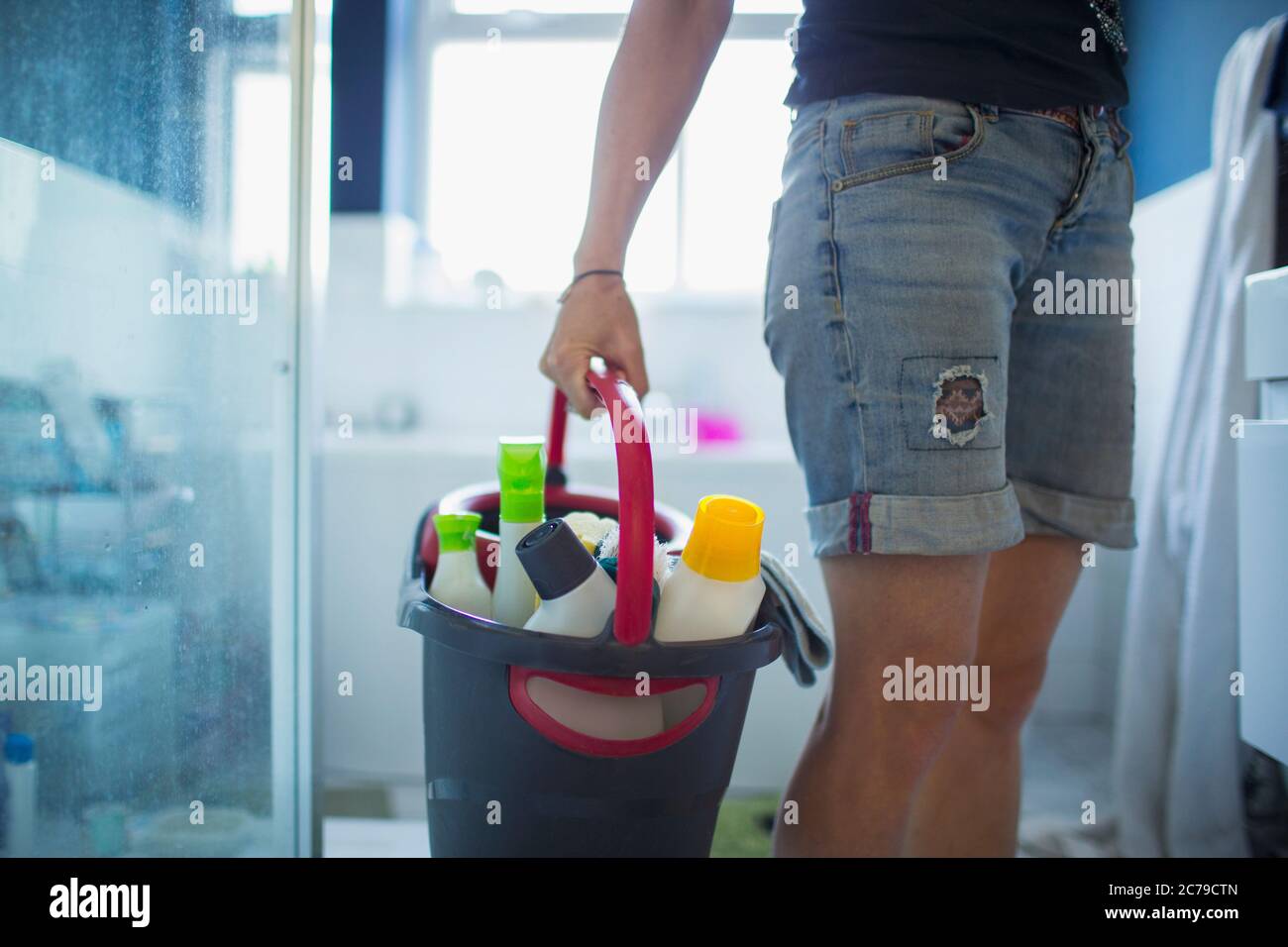 Donna con secchio di pulizia bagno Foto Stock