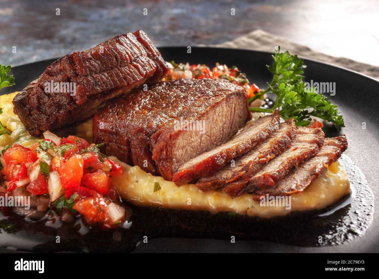 Medaglioni di manzo con salsa di pomodoro e polenta di crema Foto Stock