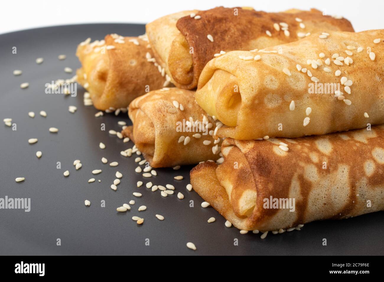 Primo piano su piatto di foie gras con pane francese croccante al sesamo in stile country e frittella russa blini isolata su bianco Foto Stock