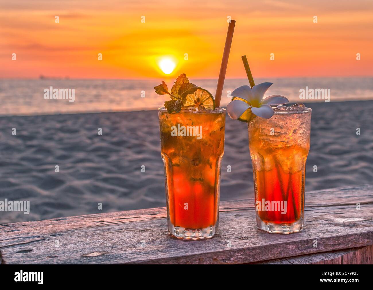 bevande con spiaggia sfocata e tramonto sullo sfondo Foto Stock