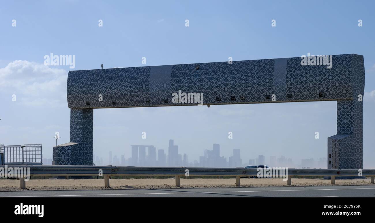 Vista in lontananza del paesaggio urbano di Abu Dhabi attraverso il ponte a pedaggio sulla Yas Island Road. Foto Stock