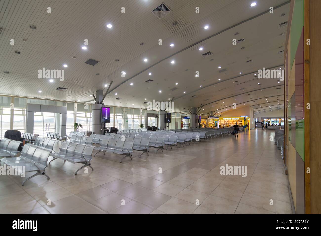 Un passeggero attraversa un terminal aeroportuale internazionale vuoto che mostra l'impatto che Covid 19 ha avuto sui voli, mentre gli aeroporti iniziano ad aprirsi di nuovo Foto Stock