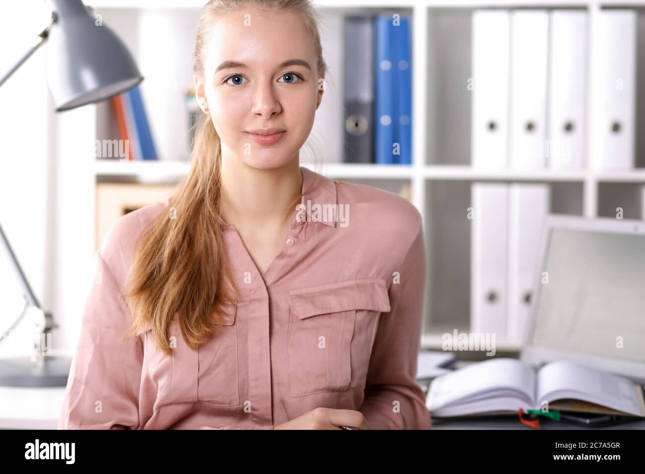 Ragazza in ufficio su cartelle e libri di sfondo Foto Stock