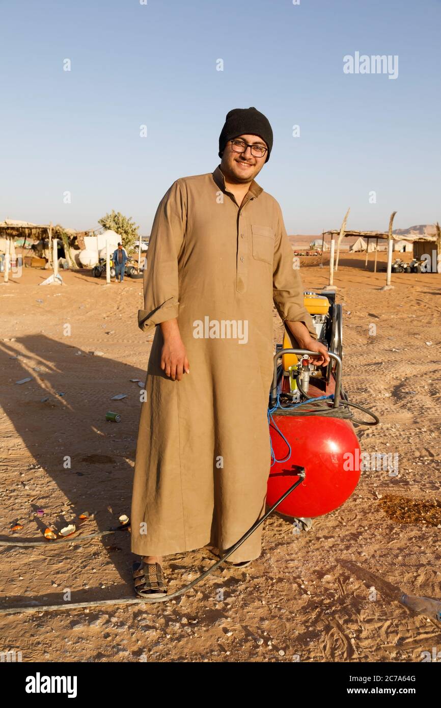 Riad, Arabia Saudita, febbraio 15 2020: Un giovane Saudita si alza con il suo compressore sul lato della strada e attende i piloti che vogliono gonfiare il loro Foto Stock
