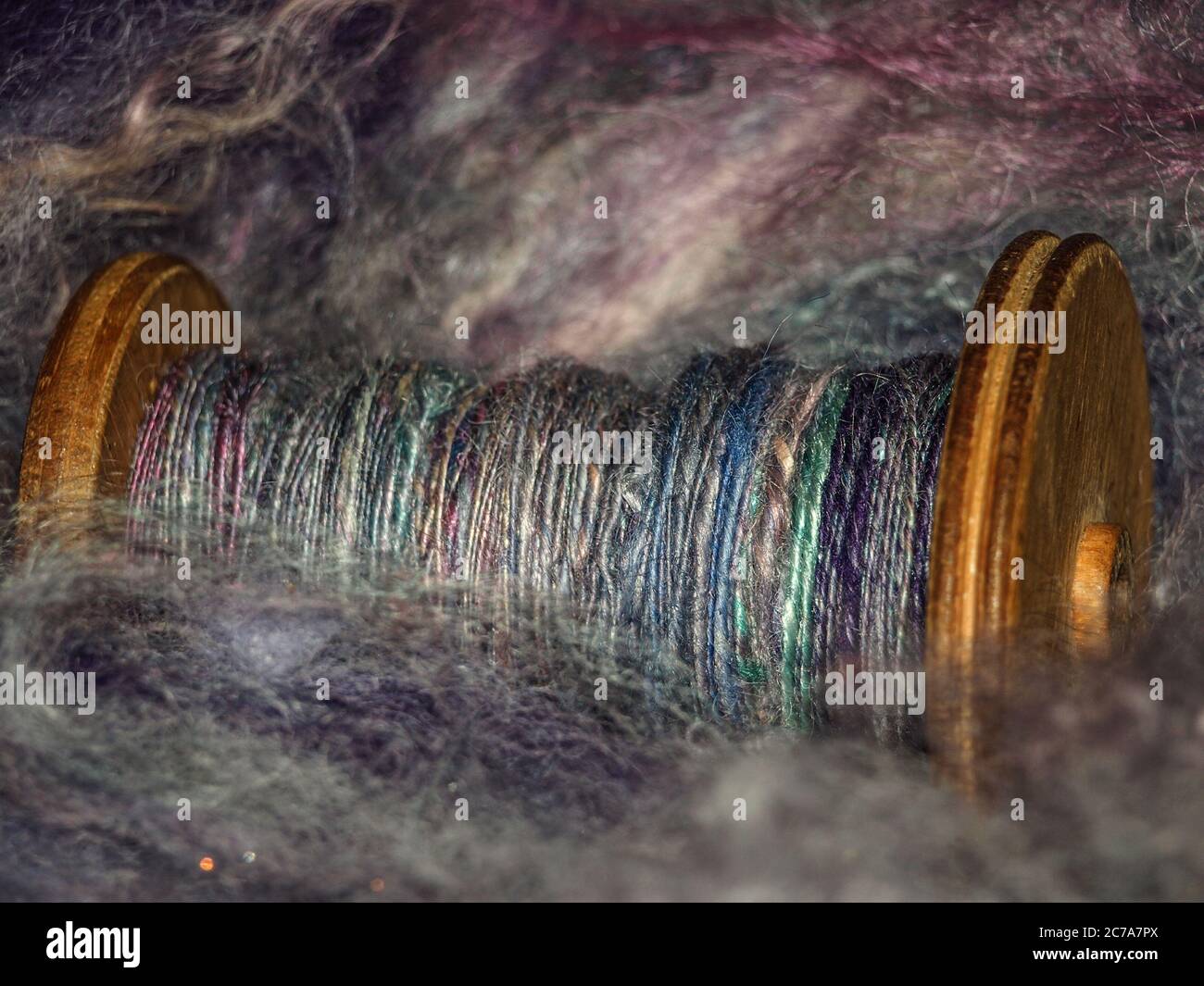 Filato a mano su una bobina di legno poggiante su fibra filante Foto Stock
