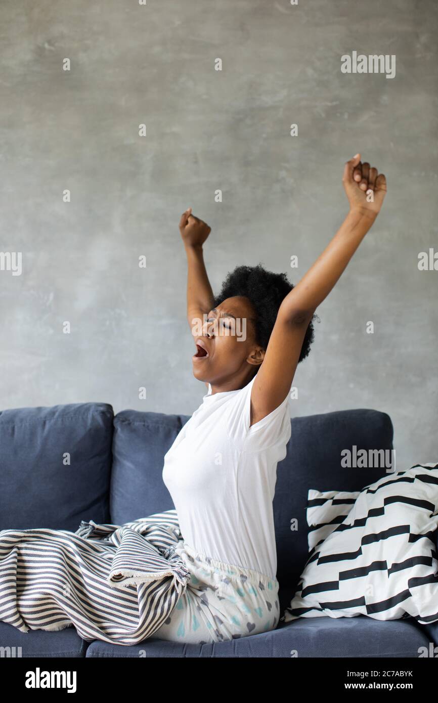 Felice african American giovane donna si sveglia. Felice di trasferirsi in un nuovo appartamento. Foto Stock
