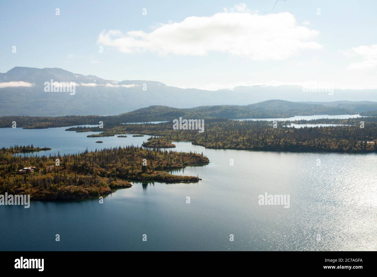Vista aerea panoramica del lago Iliamna circondata da isole boschive e montagne lontane, che mostrano la natura incontaminata e selvaggia Foto Stock