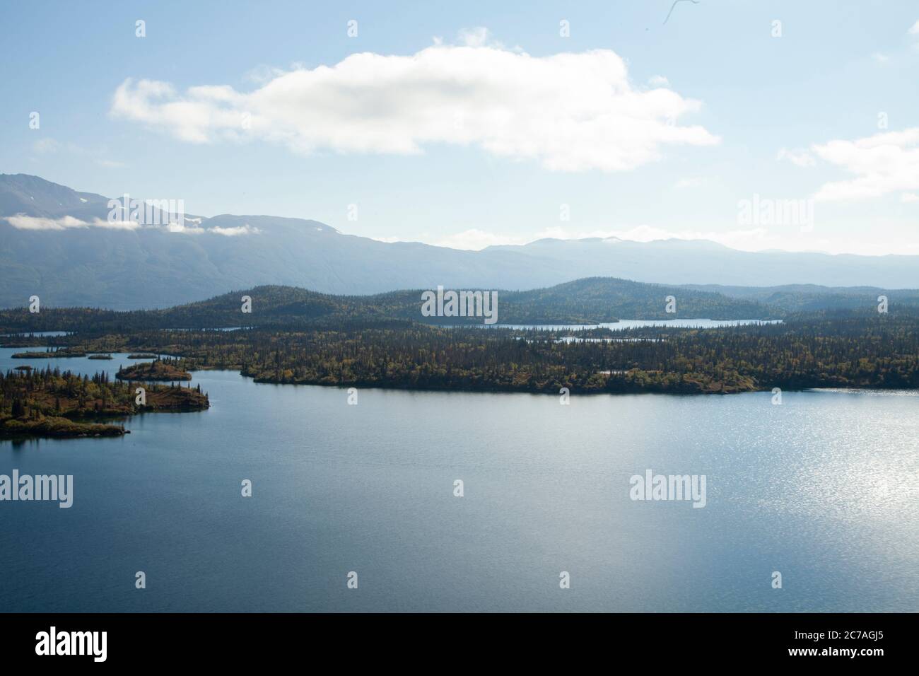 Vista aerea panoramica del lago Iliamna circondata da isole boschive e montagne lontane, che mostrano la natura incontaminata e selvaggia Foto Stock