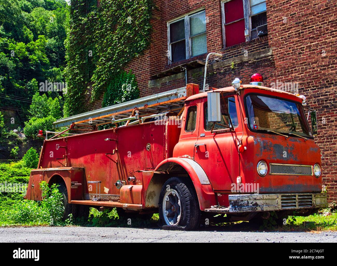 Camion abbandonato di fronte a un edificio in mattoni Foto Stock
