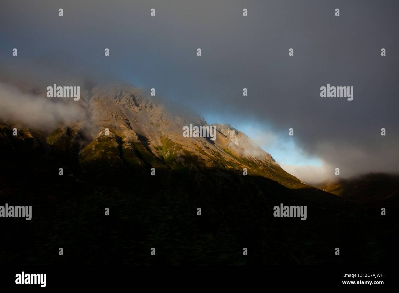 Aspre montagne in Alaska con nebbia che si snoda sulle pendici, catturando la bellezza serena e la spettacolare natura selvaggia del paesaggio remoto del lago Iliamna. Foto Stock