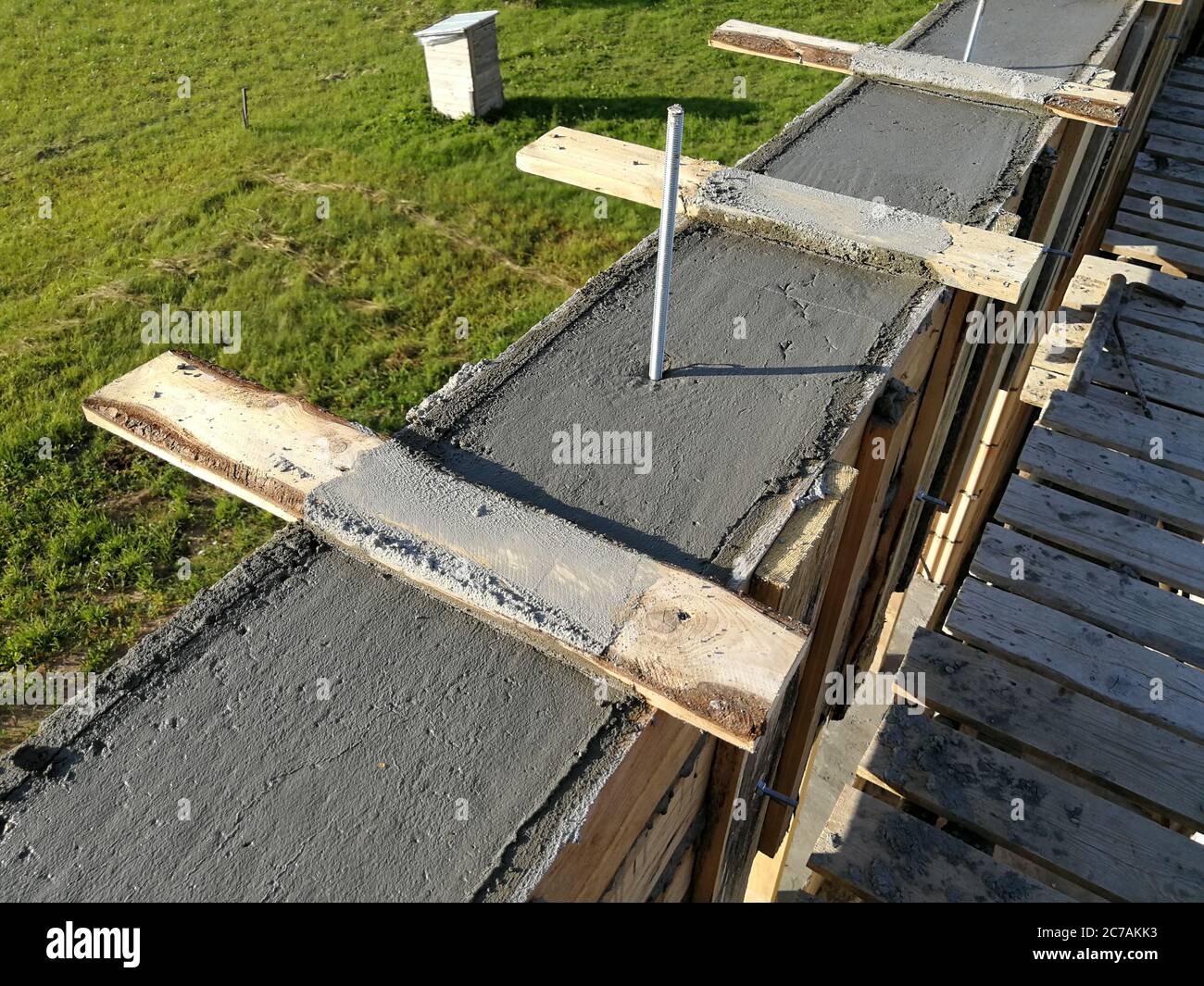 Viti metalliche inserite nel calcestruzzo bagnato per il fissaggio del tetto di una singola casa Foto Stock