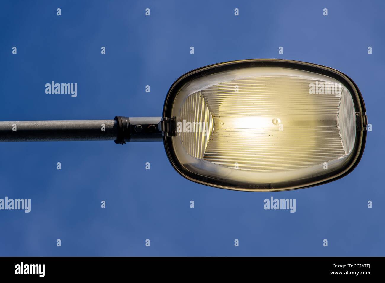 La lampada di strada che brilla contro il cielo blu. Foto Stock