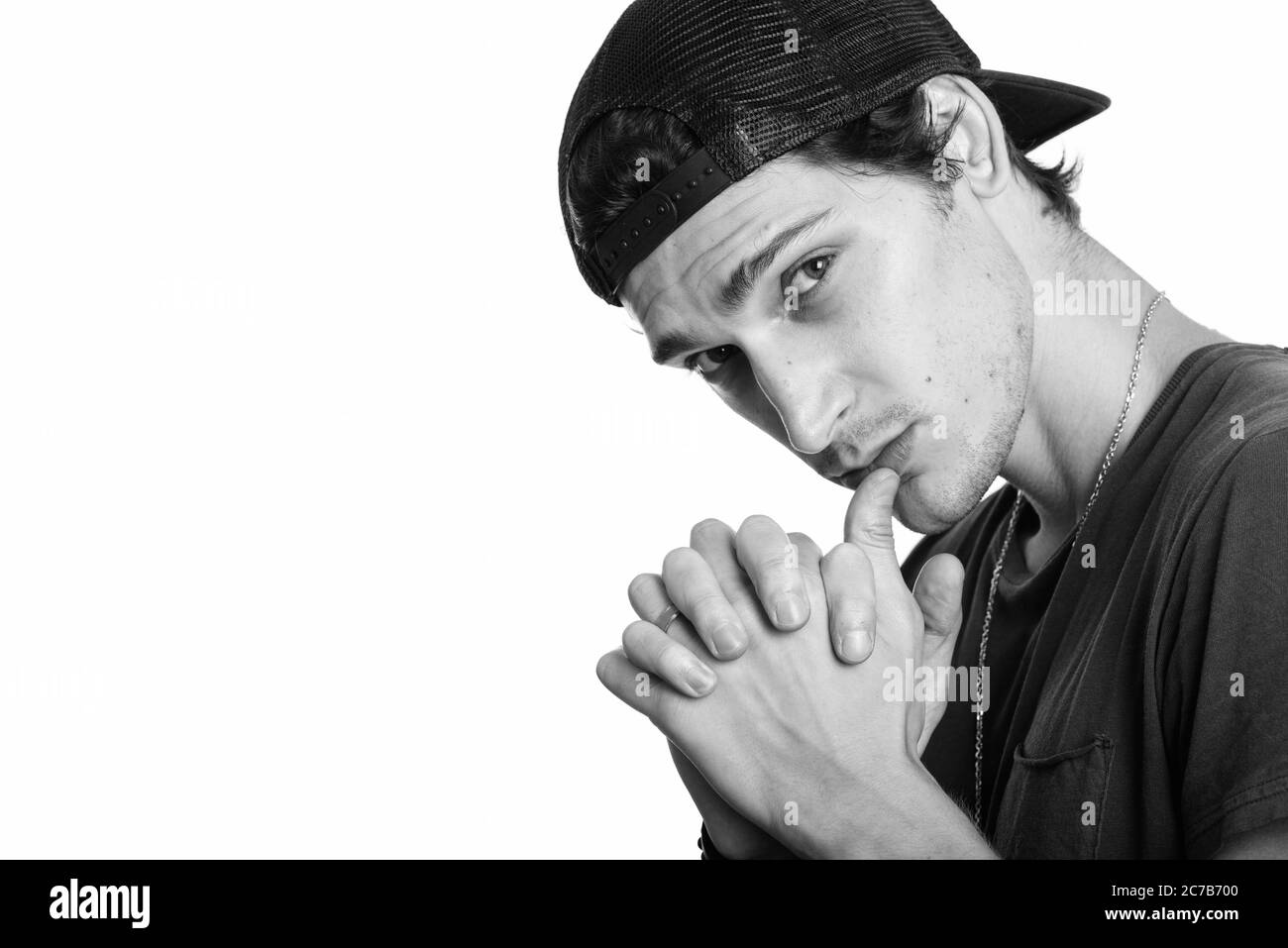 Primo piano di un giovane bell'uomo che indossa un attacco mentre si intreccia le dita Foto Stock