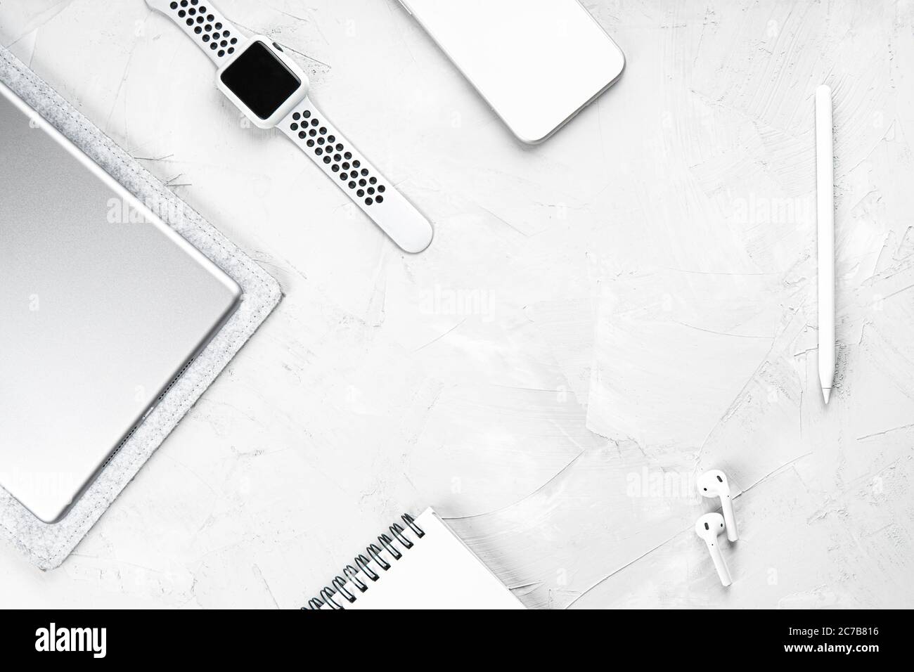 Disposizione piatta degli oggetti essenziali per l'ufficio moderni su un tavolo in cemento: Tablet digitale, smartphone, smartwatch, stilo, auricolari wireless, notebook in carta. T Foto Stock Disposizione piatta degli oggetti essenziali per l'ufficio moderni su un tavolo in cemento: Tablet digitale, smartphone, smartwatch, stilo, auricolari wireless, notebook in carta. T Foto Stock