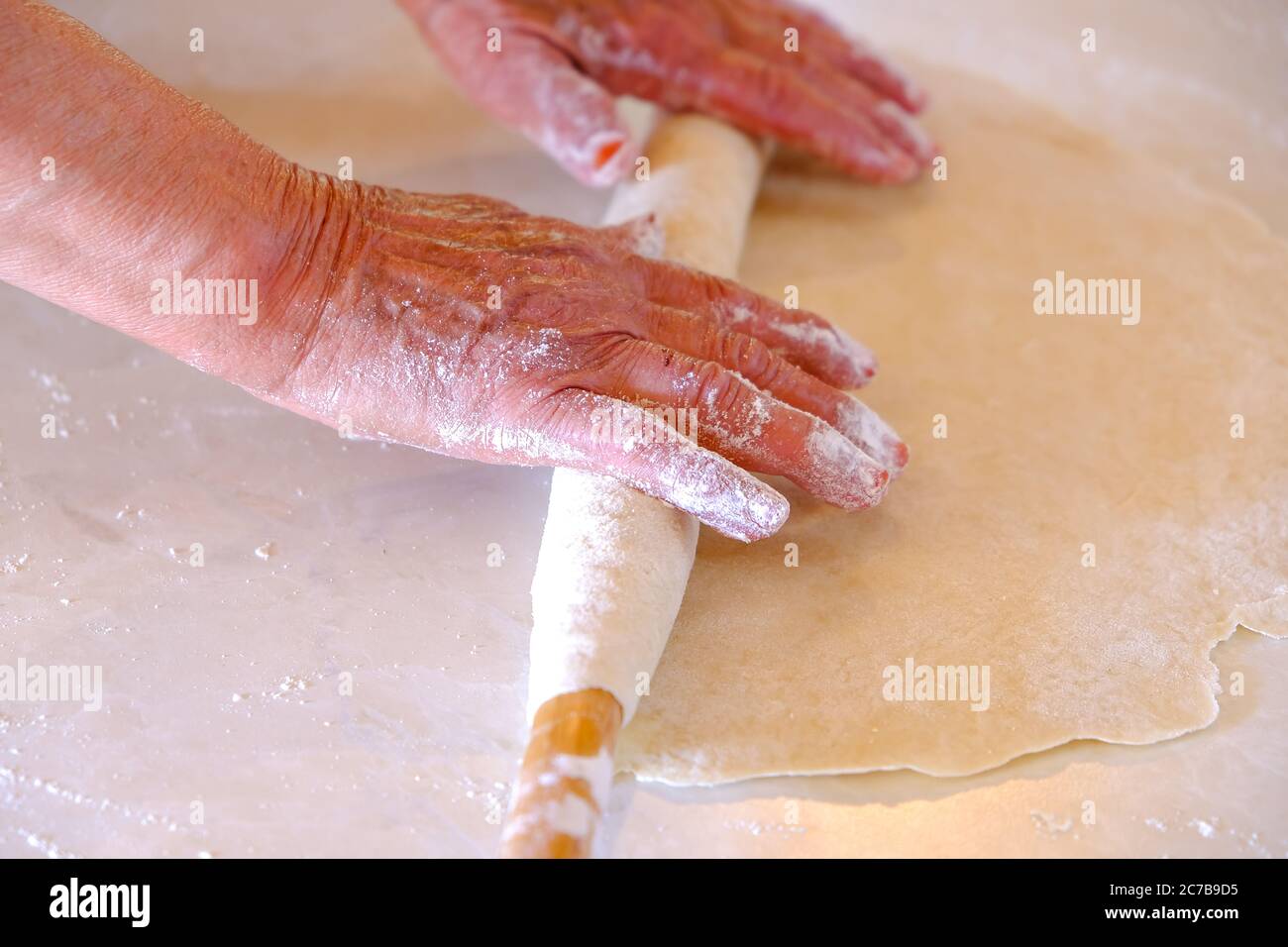 pane turco raggiante. Conosciuto anche come 'yufka ekmek', pane naturale biologico fatto in casa yufka. Donna arrotola l'impasto, primo piano. Rendere turco tradizionale Foto Stock