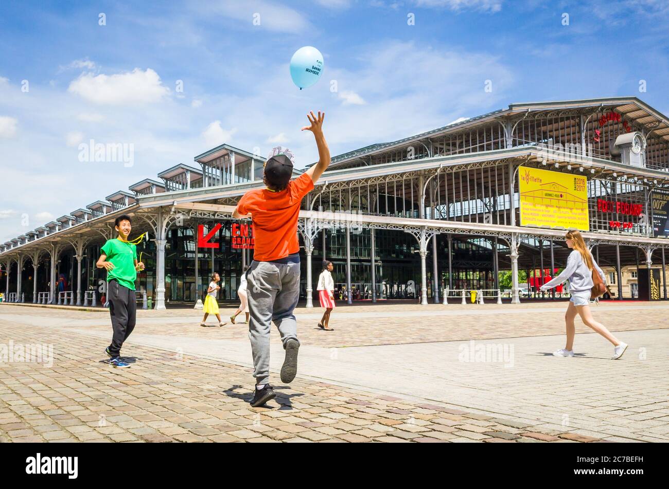 Due adolescenti che giocano con un pallone davanti alla Grande Halle de la Villette di Parigi, un ex macello trasformato in un centro culturale. Foto Stock