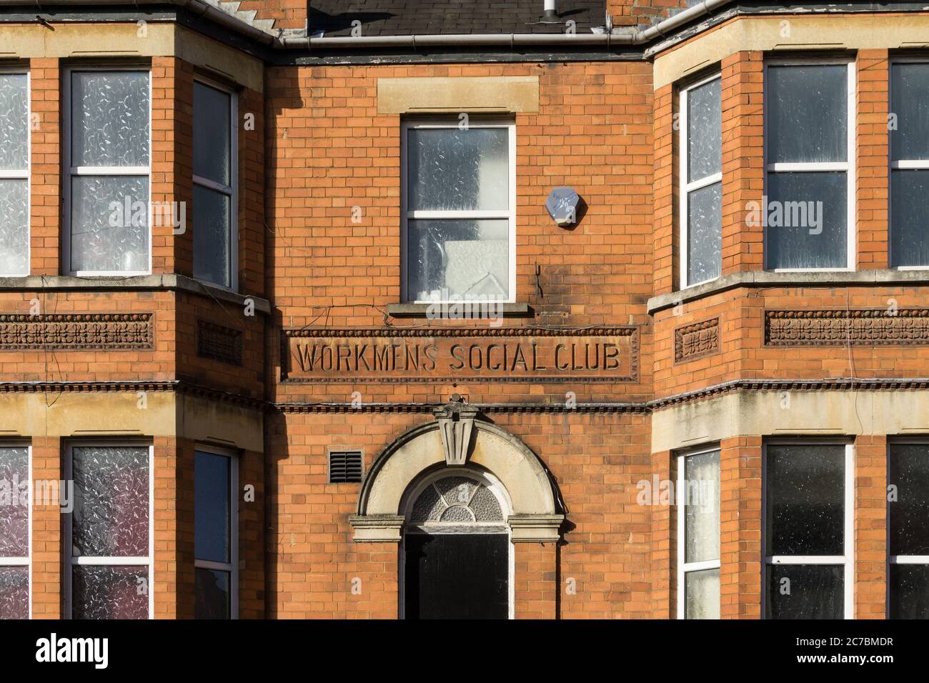 Facciata di una vecchia casa in mattoni rossi con segnaletica 'Workmens social club' Newport Pagnell, Buckinghamshire, Regno Unito Foto Stock