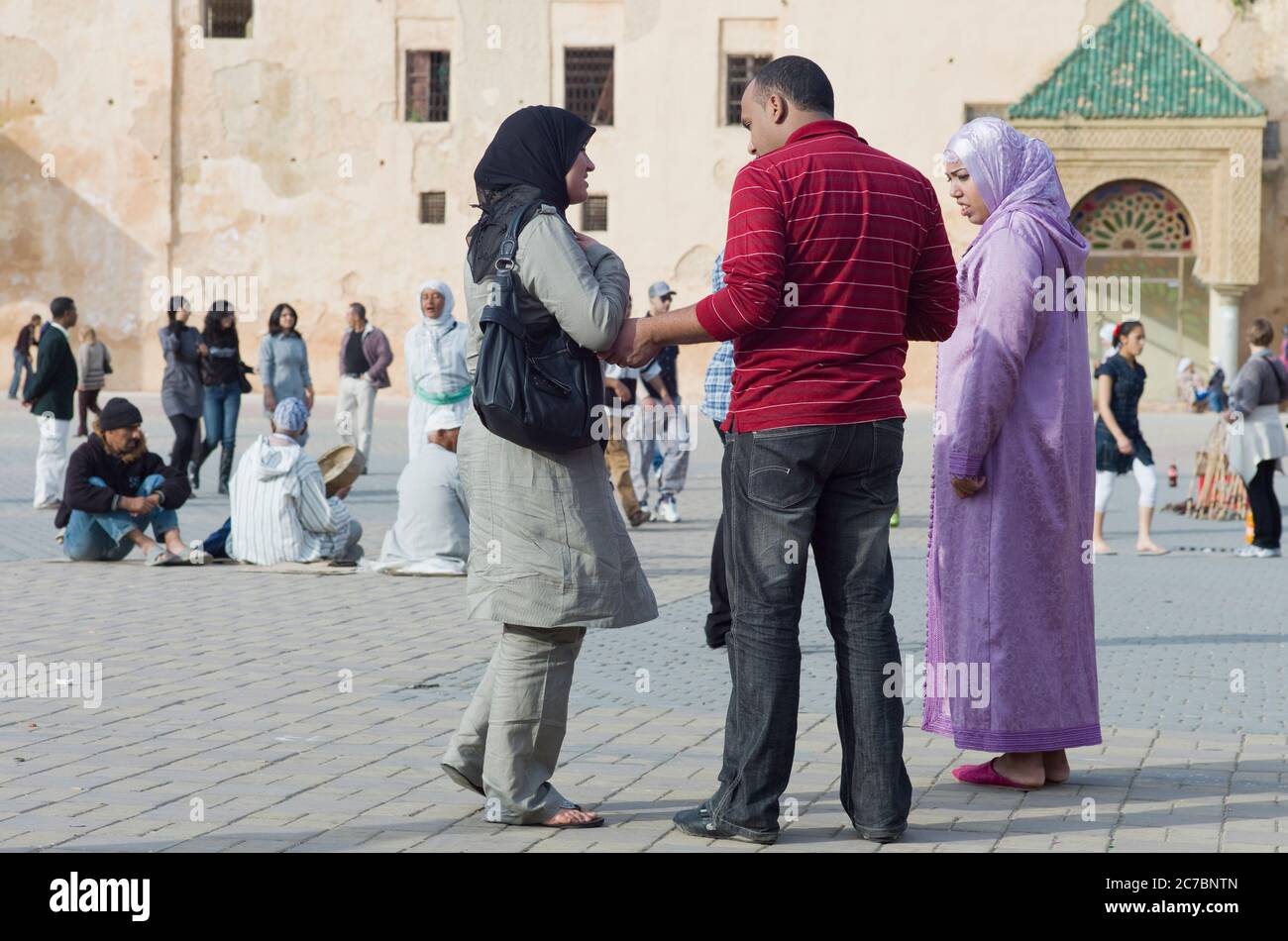 Nel pomeriggio a Meknes, Marocco, la gente marocchina sulla piazza vicino alle mura della città Foto Stock